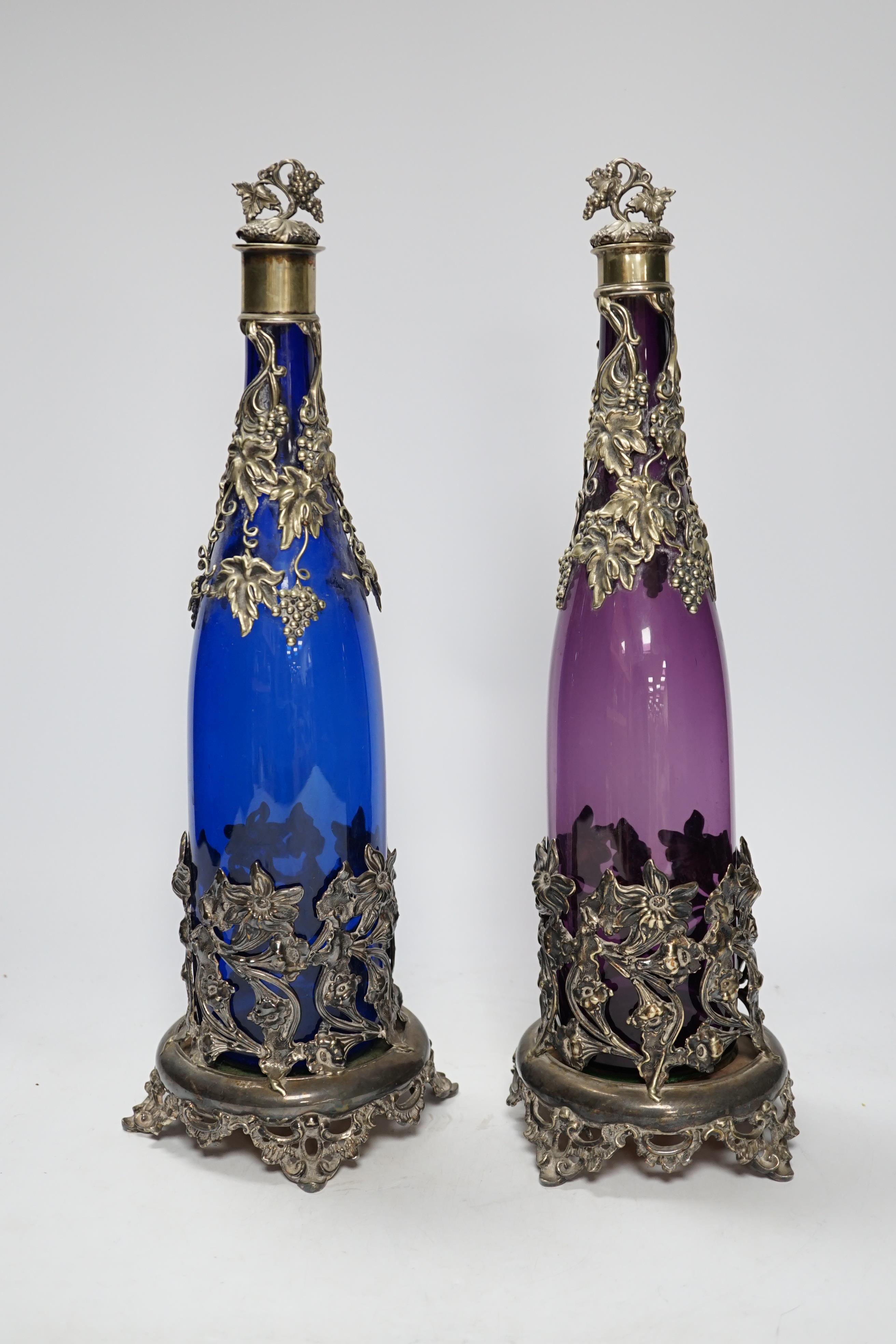 A pair of Victorian coloured glass decanters with silver plated stoppers and mounts, 38cm high